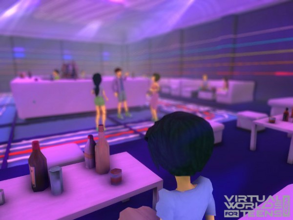 A girl is sitting in the corner looking at the other people.